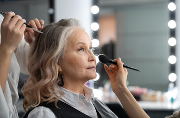 Elderly woman getting make-up and styling in a beauty salon