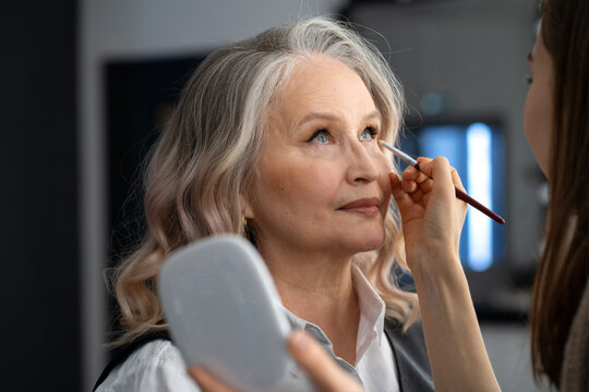 Elderly woman doing make-up in a beauty salon