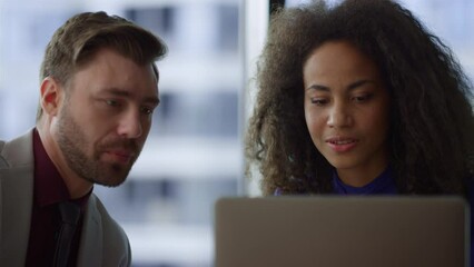 Diverse business couple working laptop computer laughing in corporate office. - Powered by Adobe