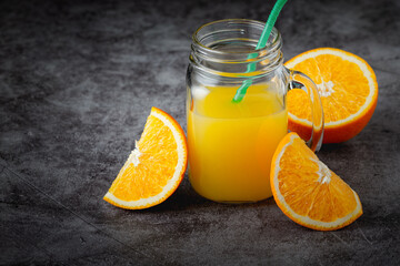 Obraz na płótnie Canvas A glass of orange juice on a dark background