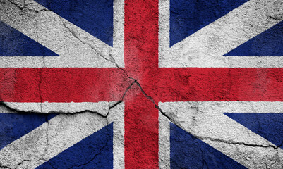 Full frame photo of a weathered British (United Kingdom, UK) flag (Union Jack) painted on a cracked wall.