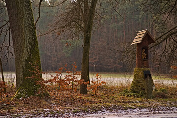 Zima , polana w lesie , rude liście , szarość zimowa , stara zabytkowa  kapliczka św. Huberta. Winter, a clearing in the forest, red leaves, winter gray, old historic - St. Hubert .  © Grzegorz