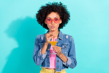 Photo of impressed cute young lady dressed denim jacket glasses enjoying beverage isolated teal color background