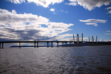 The long Governator Cuomo Bridge with clouds and blue sky on the Hudson river