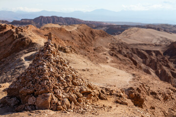 Ein roter Steinhaufen vor dem Wanderweg, welcher sich durch das Tal des Todes (Valle de la Muerte) in der Atacama Wüste zieht