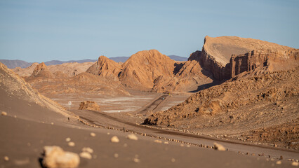 Eine Straße führt durch die roten Fels- und Lehmformationen des beeindruckenden Valle de la Luna,...