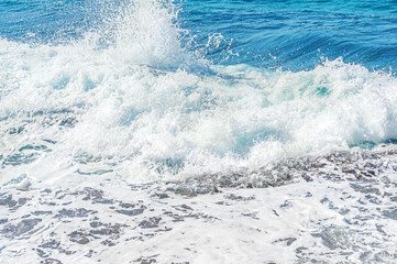 abstract background of sea surf on a rocky shore in a clear windy weather