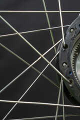 Repair of electric bicycles. A bicycle mechanic holds a wheel with an electric motor and a wrench in his hands. Bicycle wheel close-up on a black background.