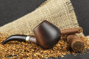 Classic wooden pipe with cigars and tobacco on linen canvas background