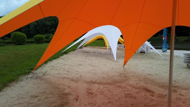 Umbrella in the form of a tent on the beach of the
