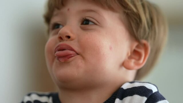 Cute little boy spitting to camera sticking tongue out being playful