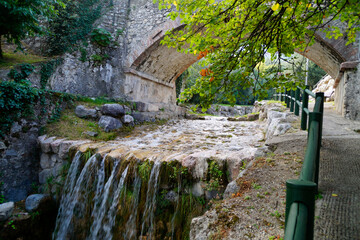 an ancient stone bridge over the San Giovanni stream (Torrente San Giovanni) in gorgeous green...