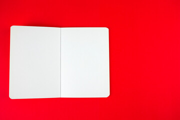Empty blank paper notebook or book mockup on red background. White empty paper notepad