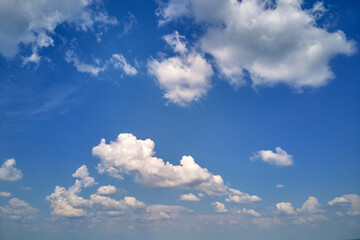 Bright landscape of white puffy cumulus clouds on blue clear sky