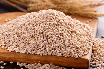 Raw organic Pearl barley on wooden board