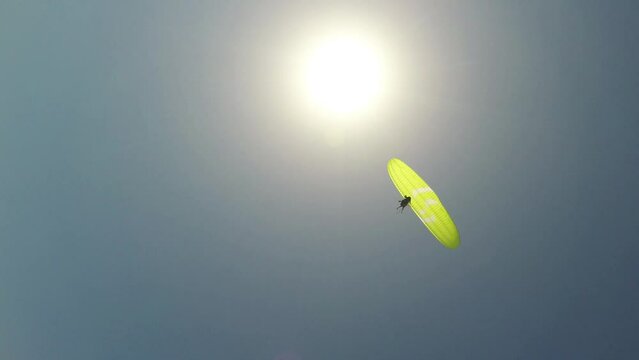 Paragliding without a motor. Dizzily flying on a tandem paraglider against the backdrop of the shining sun