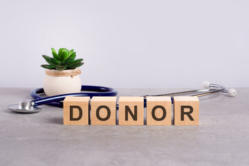 donor word written on wooden blocks and stethoscope on light gray background