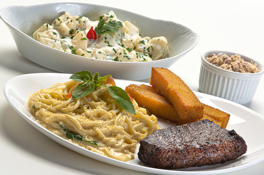 Four-cheese spaghetti served with filet and fried polenta, served with salad.