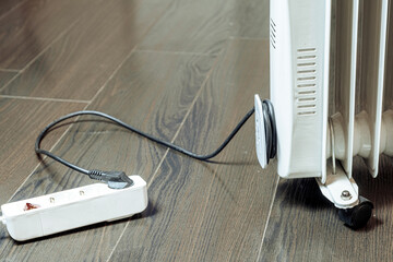 View of the white extension cord on the floor with the heater turned on.