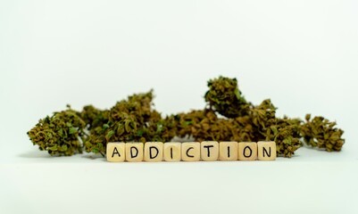 The word ADDICTION, spelled with wooden letters wooden cube on a plain white background, concept...