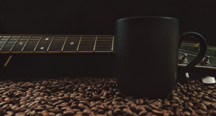 Acoustic Guitar, guitar fretboard, black coffee cup and roasted coffee beans spread on the table,...