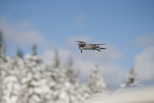 Aerial photography from a bird's eye view, a helicopter flies in the forest, takes pictures of nature. On a winter day in the forest, a professional drone with a 4K camera shoots a video.