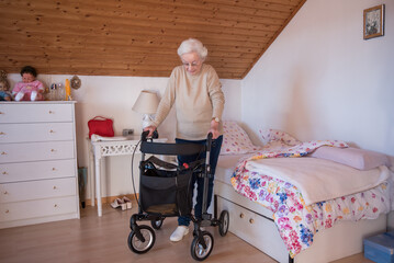Handicapped senior woman with rollator walker at home - 486371401
