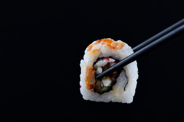sushi with black chopsticks on black background © Iryna