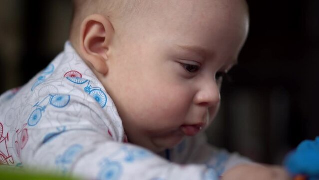 Newborn Active Baby Cute Smiling Teethless Face Portrait Early Days On Stomach Developing Neck Control. 5 Months Child In Playpen Gnaws Toys Look At Camera. Infant, Childbirth, Beginning Concept