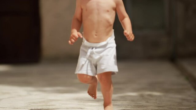 Kid running outside shirtless active little boy runner