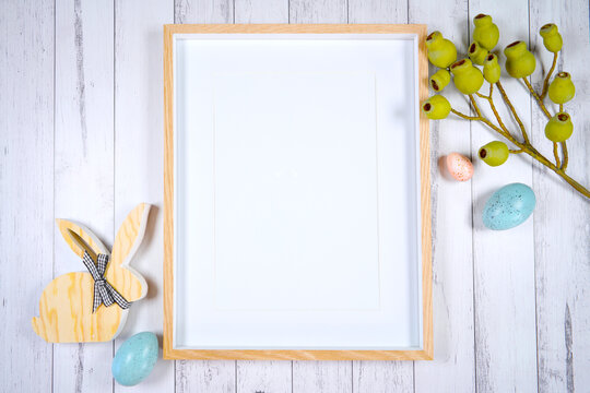 Vertical picture frame mockup. Happy Easter farmhouse theme SVG craft product mockup styled with wooden bunnies and pastel eggs against a white wood background.
