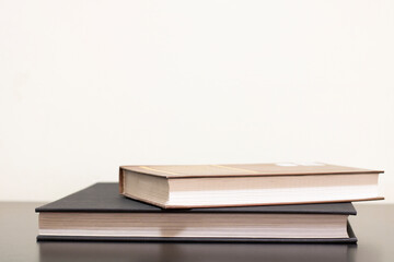 Books in colored covers on a dark wooden table. Copy space, knowledge concept.