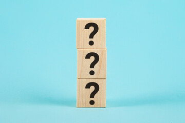 QUESTION The shape of a wooden cube block with a question mark symbol on a blue background. The question marks on the wooden block