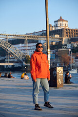 Obraz premium A Caucasian woman with an orange jacket smiling in Porto