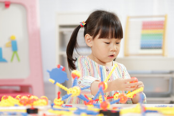 young girl playing creative 3d shape toy for homeschooling