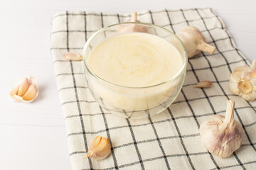 Lebanese garlic sauce Toum on a white table. Universal garlic sauce