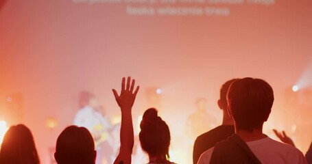 Christian Believers with Raised Hands Sing on Music Live Concert or Show Event with Lights. Young People Worship and Praise on Festival or Conference. 4K back view handheld medium shot in slow motion