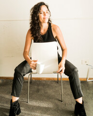 woman sitting on a chair drinking coffee