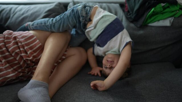 little boy upside down on sofa at home playful child at home playing