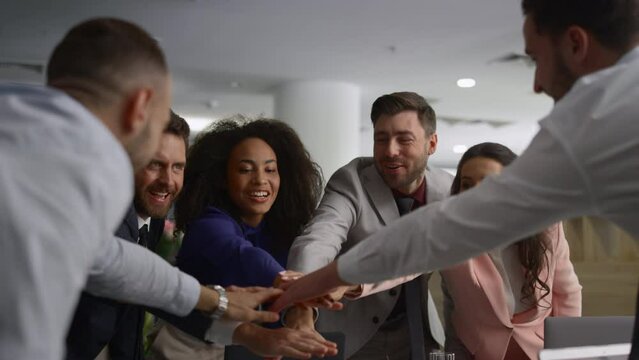 Diverse employees celebrate success. Business team high five on office meeting.