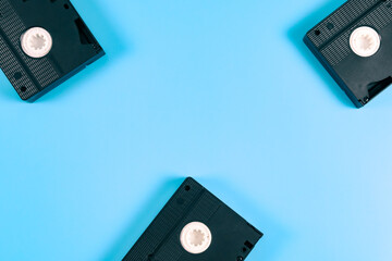 Three retro videotapes lie on the sides against a blue .