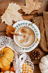 Cup of Pumpkin Spice Latte and Fall Decor from fresh  pumpkins. Traditional Coffee Drink for Autumn Holidays, cozy, hygge, comfortable