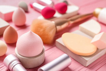 Different makeup sponges on color wooden background, closeup