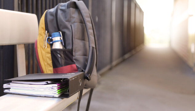 A Students Full Backpack Complete With Water Bottle On A Bench Seat With An Organized Ring Binder Folder Full Of School Books And Notes. High School Education Theme