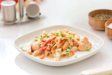 Plate with cajun chicken pasta on light table