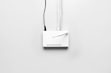 Wi-Fi router with antenna and network cables on light background