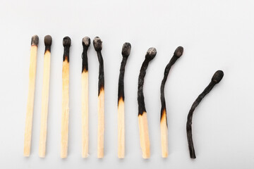 Row of matches on white background. Concept of different human life phases