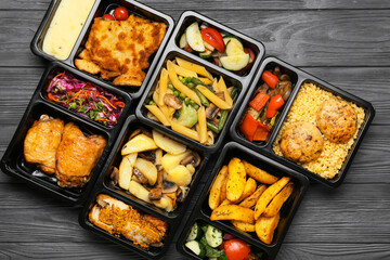 Lunch boxes with different tasty food on grey wooden background