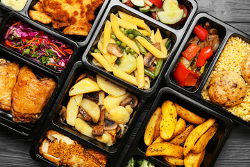 Lunch boxes with different tasty food on grey wooden background, closeup