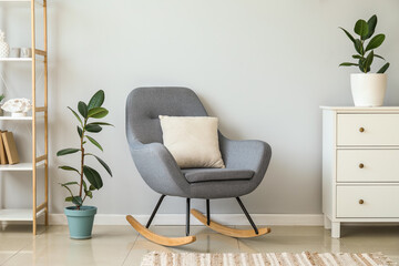 Interior of light living room with armchair and houseplants